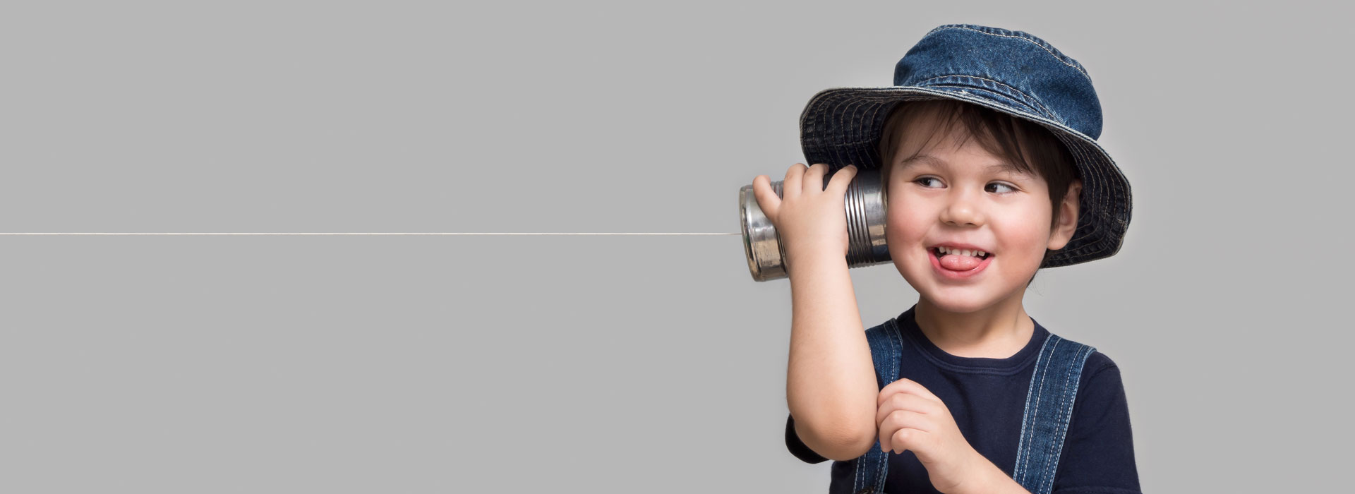 Young child with string and can telephone